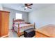 Cozy bedroom features a ceiling fan, window, and a wooden bed frame with storage bench at 12524 Highway 36, Covington, GA 30014