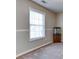 This bedroom has neutral paint, carpet, and features a fish tank by a sunny window at 12524 Highway 36, Covington, GA 30014