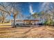 Back exterior view of a single-story home with an open patio area and ample lawn space at 12524 Highway 36, Covington, GA 30014