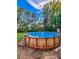 Above-ground pool featuring clear water, surrounded by lush greenery and a wooden plank exterior at 12524 Highway 36, Covington, GA 30014