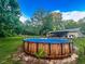 Backyard showing an above-ground pool, with deck space, complemented by green lawn and shade trees at 12524 Highway 36, Covington, GA 30014