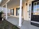 Covered front porch with white columns and a black front door at 1760 Marceau Dr, Conley, GA 30288
