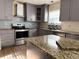 Modern kitchen with gray cabinets, granite countertops, and stainless steel appliances at 1760 Marceau Dr, Conley, GA 30288