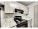 Kitchen features gray cabinets, granite countertops, and black appliances at 3102 Fairington Village Dr, Lithonia, GA 30038