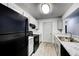 Modern kitchen with gray cabinets, granite countertops, and black appliances at 3102 Fairington Village Dr, Lithonia, GA 30038