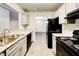 Modern kitchen with gray cabinets, granite countertops, and black appliances at 3102 Fairington Village Dr, Lithonia, GA 30038