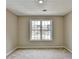 Bright bedroom with large window and neutral carpeting at 591 Paper Ridge Ct, Lawrenceville, GA 30046