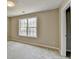 Simple bedroom with neutral walls, carpet flooring, and a large window at 591 Paper Ridge Ct, Lawrenceville, GA 30046