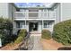 Two-story condo building featuring gray siding, white railings, and well-maintained landscaping at 2042 Brian Way, Decatur, GA 30033