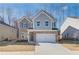 Two-story home with brick and gray siding, two-car garage, and a well-manicured lawn at 277 Tulip Dr, Covington, GA 30016