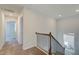 Upstairs hallway with carpet, doors to bedrooms, and a view of the staircase at 277 Tulip Dr, Covington, GA 30016