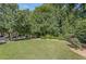 View of the backyard with lush green lawn, mature trees, and manicured landscaping, creating a serene outdoor space at 2827 Overlook Ne Trce, Atlanta, GA 30324