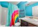 Bright bathroom with rainbow shower curtain, white sink, and dark brown vanity at 341 Harris Ave, Locust Grove, GA 30248