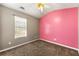 Cozy bedroom with pink accent wall, window with blinds, and neutral carpet at 341 Harris Ave, Locust Grove, GA 30248