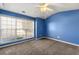 Spacious bedroom with large window, blue walls, and neutral carpet at 341 Harris Ave, Locust Grove, GA 30248