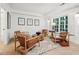 Cozy sitting area with leather armchairs, wood coffee table, and hardwood floors at 475 Rose Garden Ln, Alpharetta, GA 30009