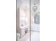 Bright bathroom with pink printed wall paper, chandelier and vanity with white drawers at 923 Little Darby Ln, Suwanee, GA 30024