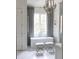 Bright bathroom featuring a soaking tub, modern fixtures, and elegant gray curtains at 923 Little Darby Ln, Suwanee, GA 30024