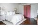 Spacious bedroom with white bedding and a pink barn door at 923 Little Darby Ln, Suwanee, GA 30024