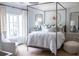 Serene bedroom featuring a four-poster bed, blue patterned wallpaper and a comfortable armchair at 923 Little Darby Ln, Suwanee, GA 30024