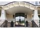 Elegant front entrance with a covered porch, stone pillars, and a modern glass door at 923 Little Darby Ln, Suwanee, GA 30024