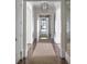 Inviting hallway featuring dark hardwood floors, neutral rugs, and pendant lighting at 923 Little Darby Ln, Suwanee, GA 30024