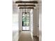 Light-filled hallway featuring exposed wooden beams and a stylish pendant light at 923 Little Darby Ln, Suwanee, GA 30024