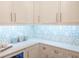 Kitchen features white cabinets, quartz countertops and patterned backsplash at 923 Little Darby Ln, Suwanee, GA 30024