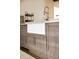 Close-up of a farmhouse sink with chrome faucet and gray wood cabinets at 923 Little Darby Ln, Suwanee, GA 30024