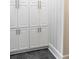 Bright laundry room with white shaker cabinets and dark grey flooring at 923 Little Darby Ln, Suwanee, GA 30024