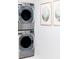 Efficient laundry room featuring stacked washer and dryer with bright white accents and decor at 923 Little Darby Ln, Suwanee, GA 30024