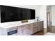 Wet bar and entertainment center featuring built-in cabinets, a beverage fridge, and a wall-mounted television at 923 Little Darby Ln, Suwanee, GA 30024