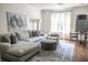 Bright living room featuring a comfortable sectional sofa, area rug, and neutral decor at 923 Little Darby Ln, Suwanee, GA 30024