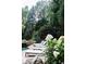 Backyard pool with stone border, lounge chairs, and lush trees at 923 Little Darby Ln, Suwanee, GA 30024