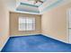 Spacious bedroom with blue carpet and tray ceiling at 1943 Ivy Branch Ct, Loganville, GA 30052