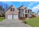 Brick two-story house with a two-car garage and landscaped lawn at 1943 Ivy Branch Ct, Loganville, GA 30052