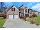 Brick two-story house with a two-car garage and landscaped lawn at 1943 Ivy Branch Ct, Loganville, GA 30052