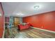 Spacious basement area with wood flooring, red walls, and a built-in bookshelf at 753 Win West Xing, Auburn, GA 30011