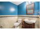 Bathroom with blue walls, a wood trimmed mirror, single sink, and tiled walls at 753 Win West Xing, Auburn, GA 30011