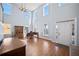 Bright living room featuring high ceilings, hardwood floors, large windows, a piano, and front door at 753 Win West Xing, Auburn, GA 30011