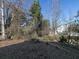 Wooded backyard with mature trees and some leaf litter at 826 Shore Drive, Lithonia, GA 30058