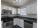 Galley-style kitchen with stainless steel appliances and white cabinets at 826 Shore Drive, Lithonia, GA 30058