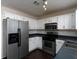 Galley-style kitchen with stainless steel appliances and white cabinets at 826 Shore Drive, Lithonia, GA 30058