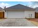 White garage with a dark roof, adjacent to a driveway at 3529 Flowering Spgs, Powder Springs, GA 30127