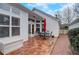 Brick patio featuring a table with an umbrella and chairs next to a white house with many windows at 3529 Flowering Spgs, Powder Springs, GA 30127