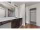 Bathroom with dark wood vanity, white countertop, and large mirror at 7369 Saint Peter Way, Fairburn, GA 30213
