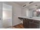 Clean bathroom with dark brown vanity and large mirror at 7369 Saint Peter Way, Fairburn, GA 30213