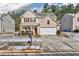 Two-story house with beige siding, brown accents, and a white garage door at 7369 Saint Peter Way, Fairburn, GA 30213