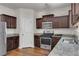 Kitchen with dark brown cabinets and granite countertops at 7369 Saint Peter Way, Fairburn, GA 30213