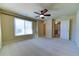 Spacious bedroom with carpeted floor, ceiling fan, and large window at 5705 Upper Creek Ct, Suwanee, GA 30024